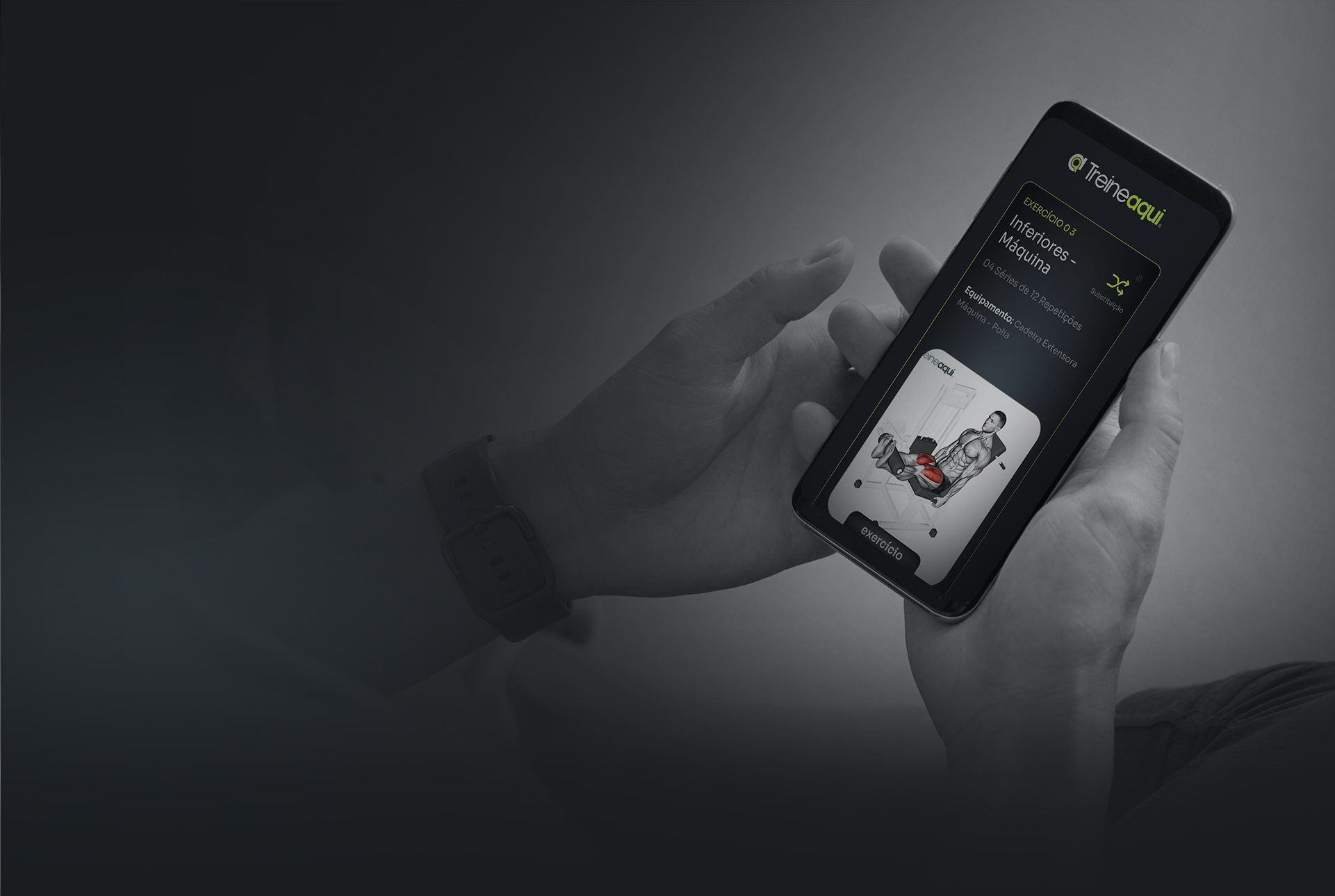 Mãos segurando o celular com o app TreineAqui aberto no exercício Inferiores, máquina
